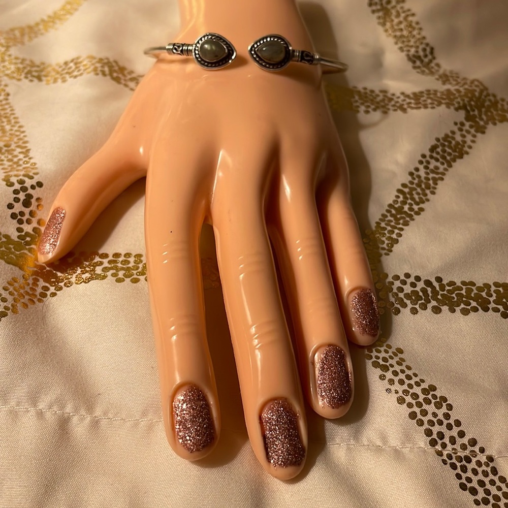 Silver colored bracelet adjustable with a gray stone on end of each side. NWOT
